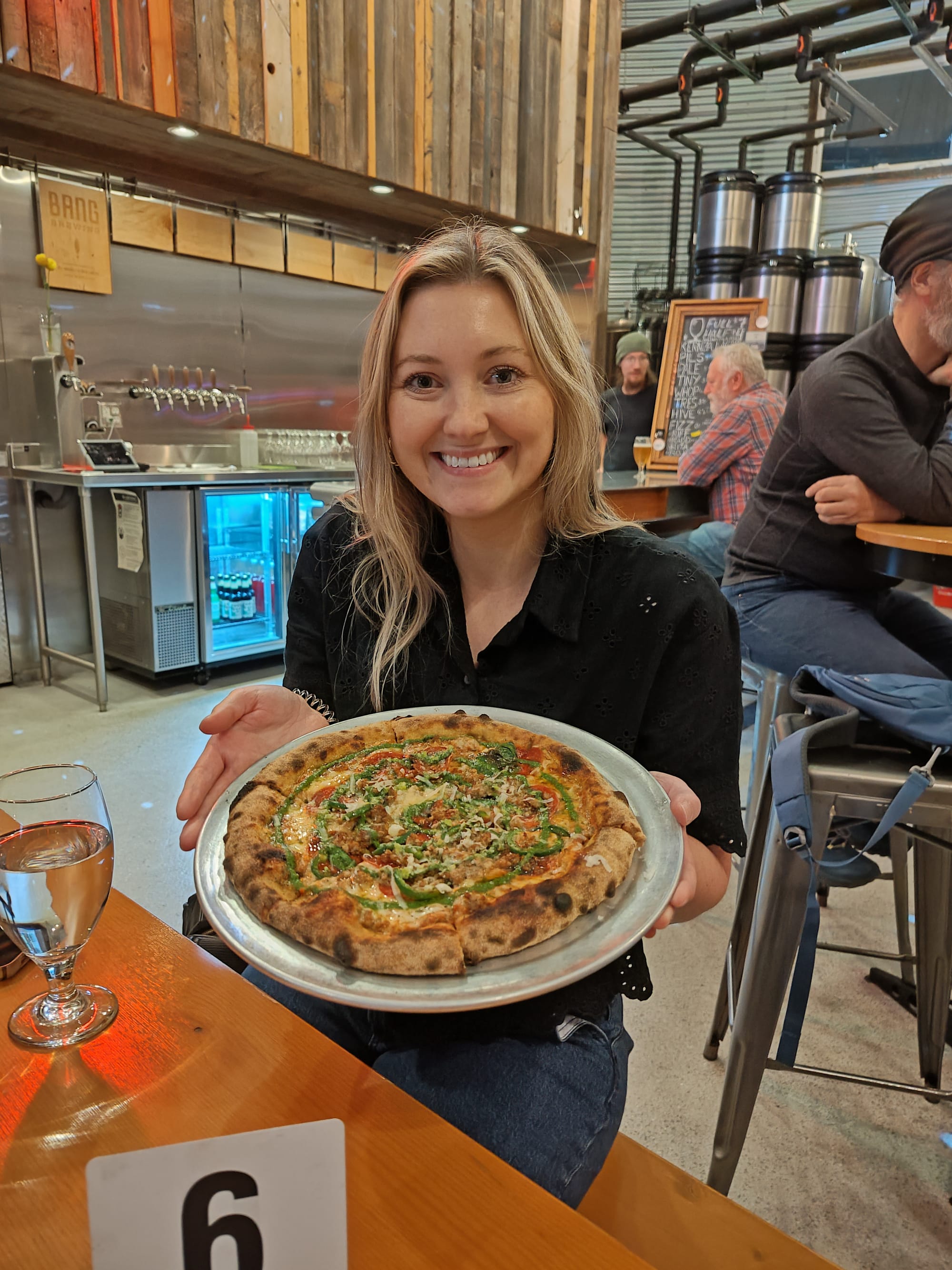 woman holding a spicy pizza pie