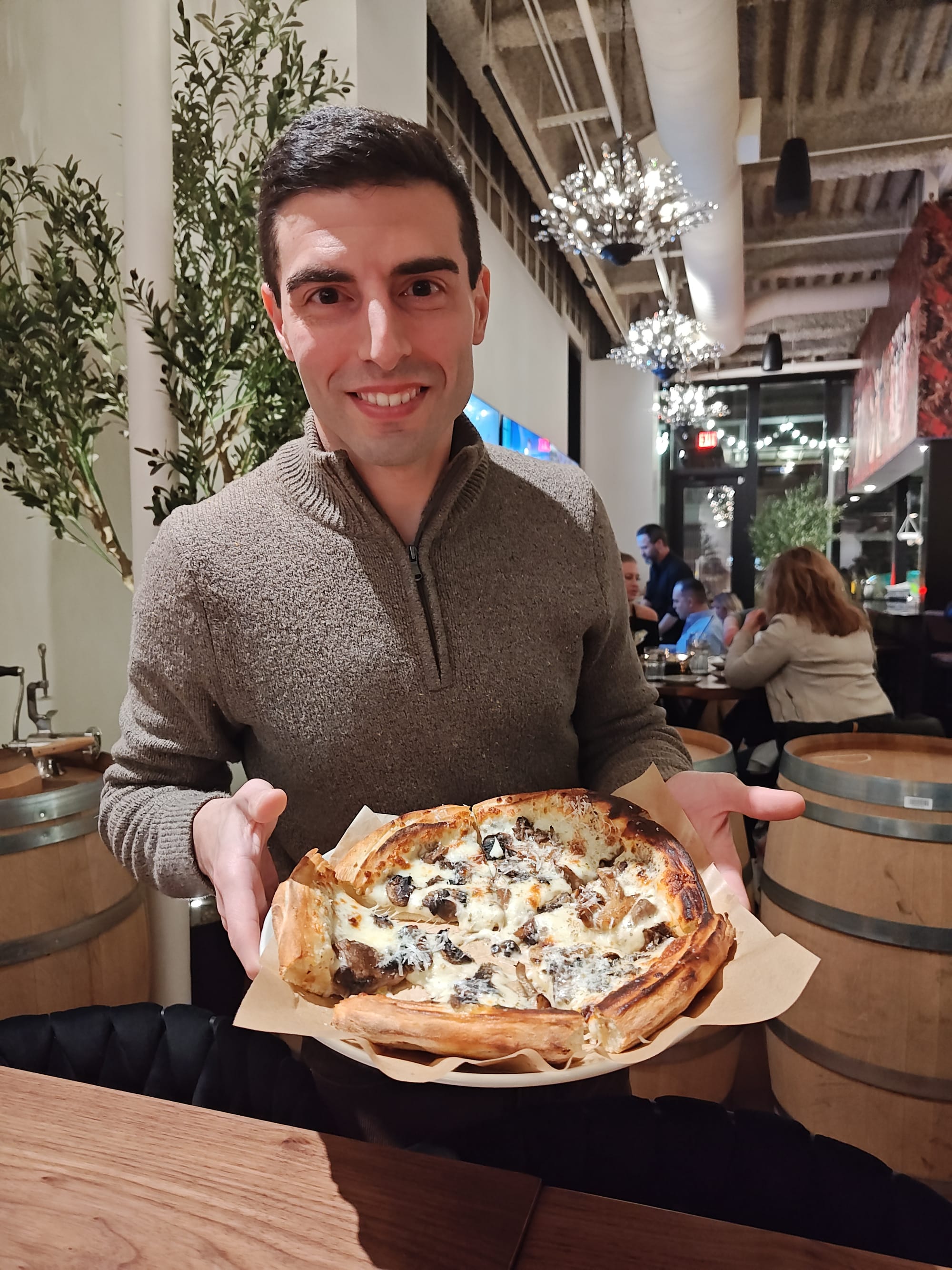 man holding mushroom pizza